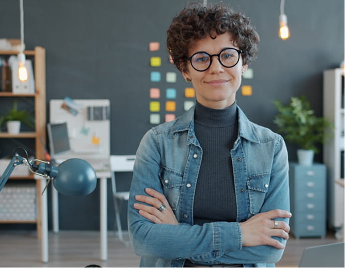 オフィスで腕を組んで立つ若手ビジネスパーソン
