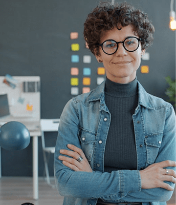 丸眼鏡の人物が教室で微笑むポートレート