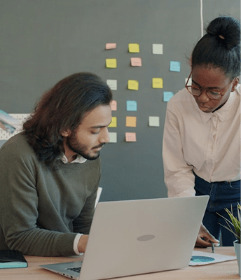 丸眼鏡の人物が教室で微笑むポートレート